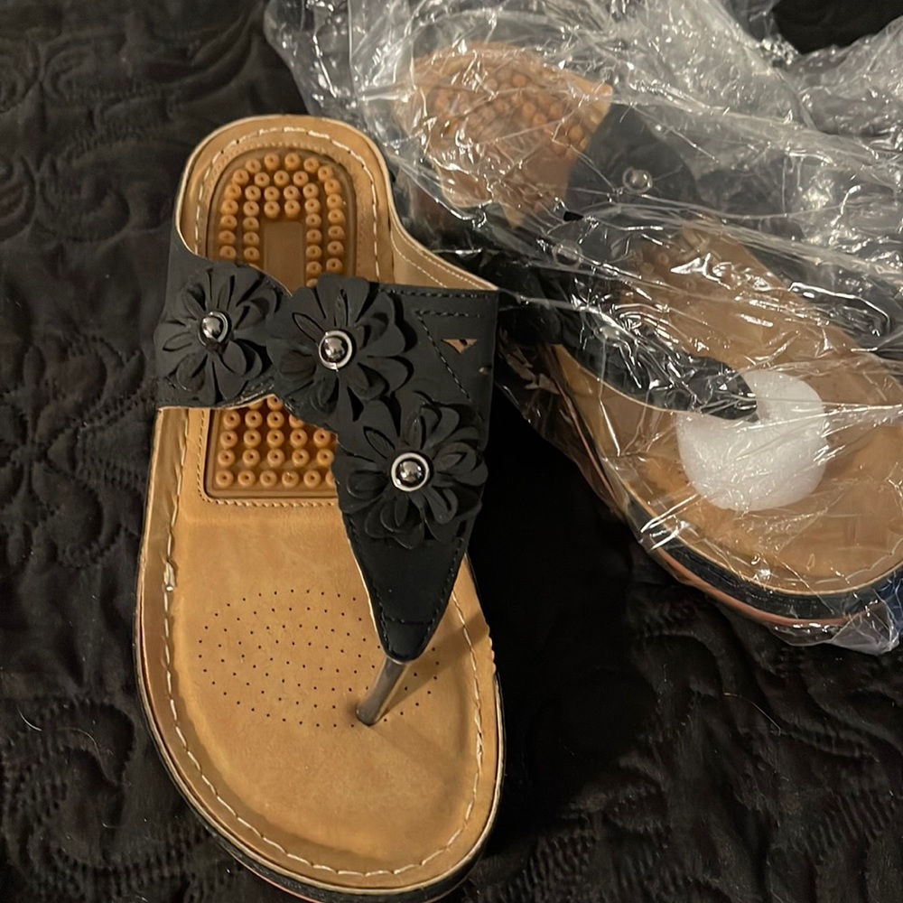 Black, adjustable strap flip flops with massaging sole